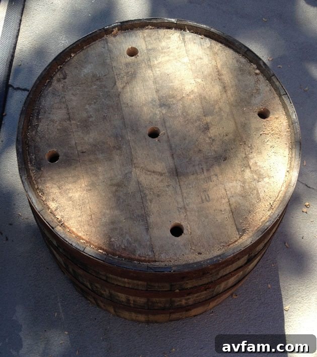 Drilling drainage holes in the bottom of a whiskey barrel planter using a spade bit
