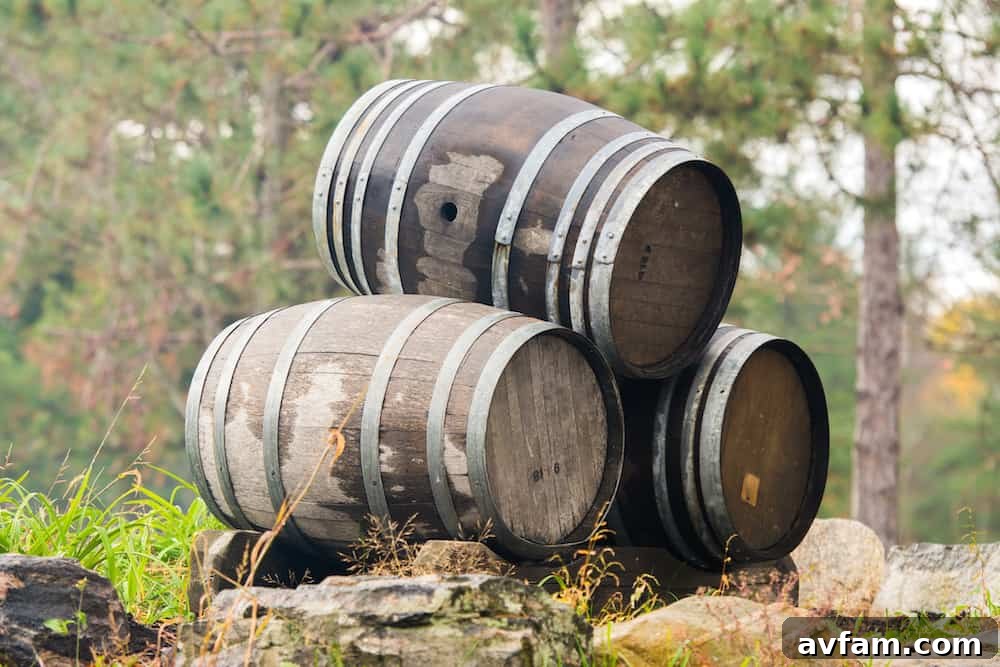 A flourishing garden scene featuring multiple whiskey barrel planters showcasing vibrant plants