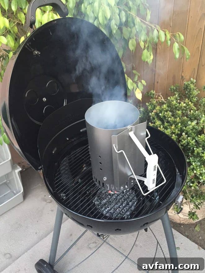 Charcoal chimney starter in action, preparing coals for grilling.