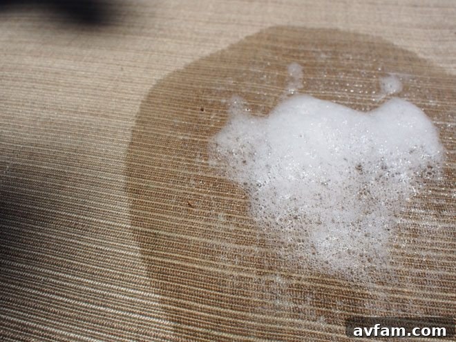 Scotts Outdoor Cleaner Plus OxiClean creating a foam on patio furniture, actively lifting dirt