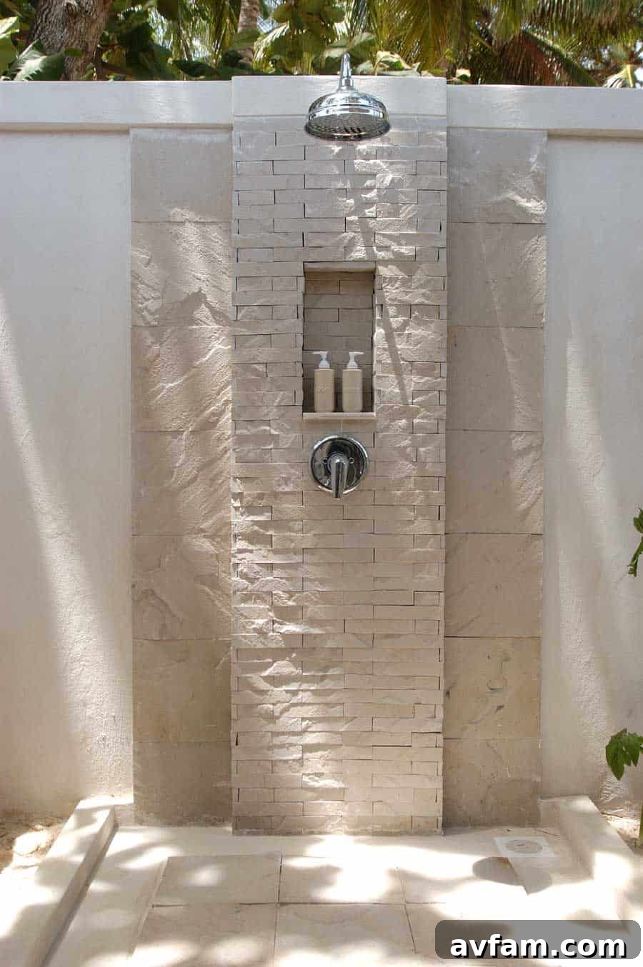 Luxurious outdoor shower with natural stone walls and lush plants