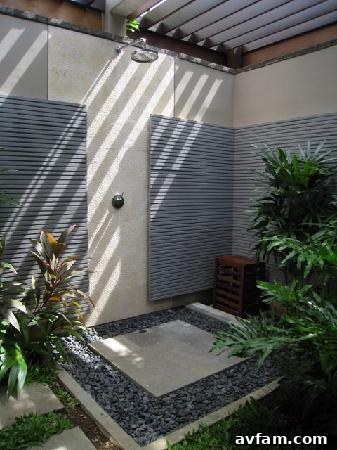 Outdoor shower with green tile accents and wooden floor