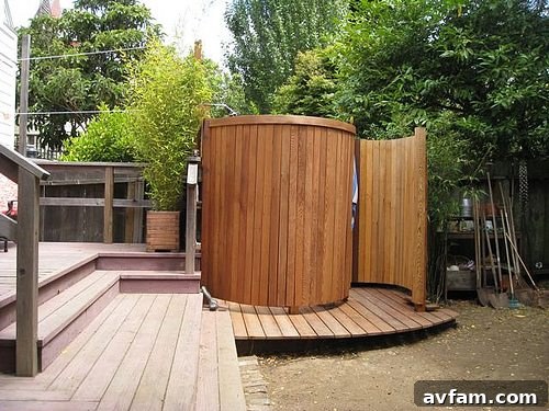 Outdoor shower with simple wood plank enclosure and overhead showerhead
