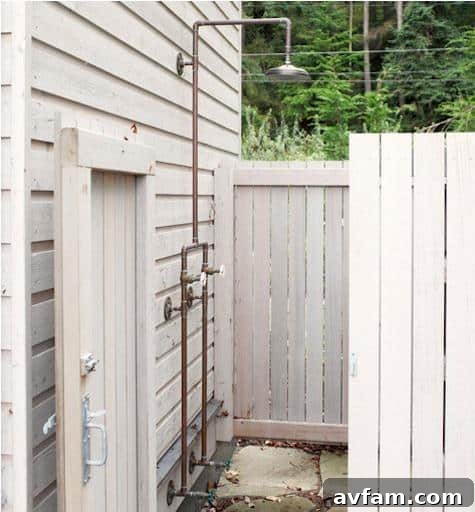 Outdoor shower with natural wood walls and pebble flooring