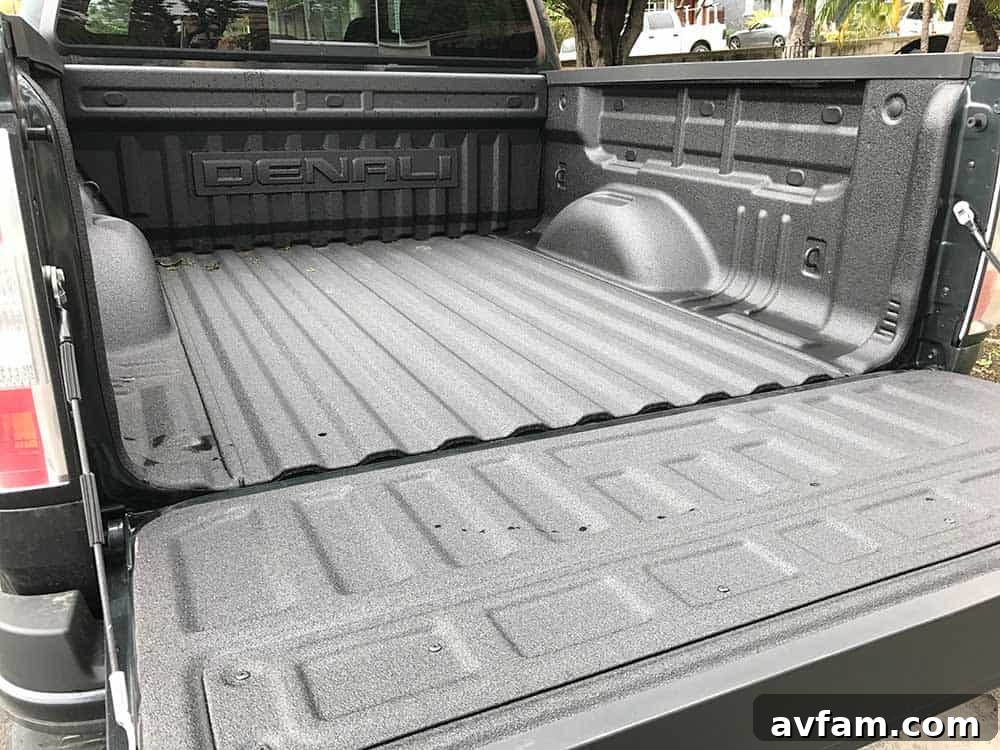 Denali Tailgate and Bed Rear view of the GMC Canyon Denali with its tailgate down, showcasing bed utility and lights