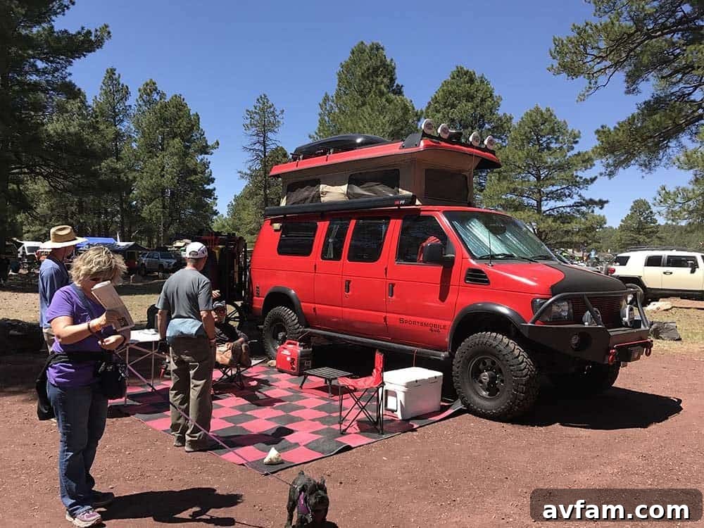 A white Ford Ranger pickup truck, customized for overlanding with a bed rack, rooftop tent, and auxiliary lighting.