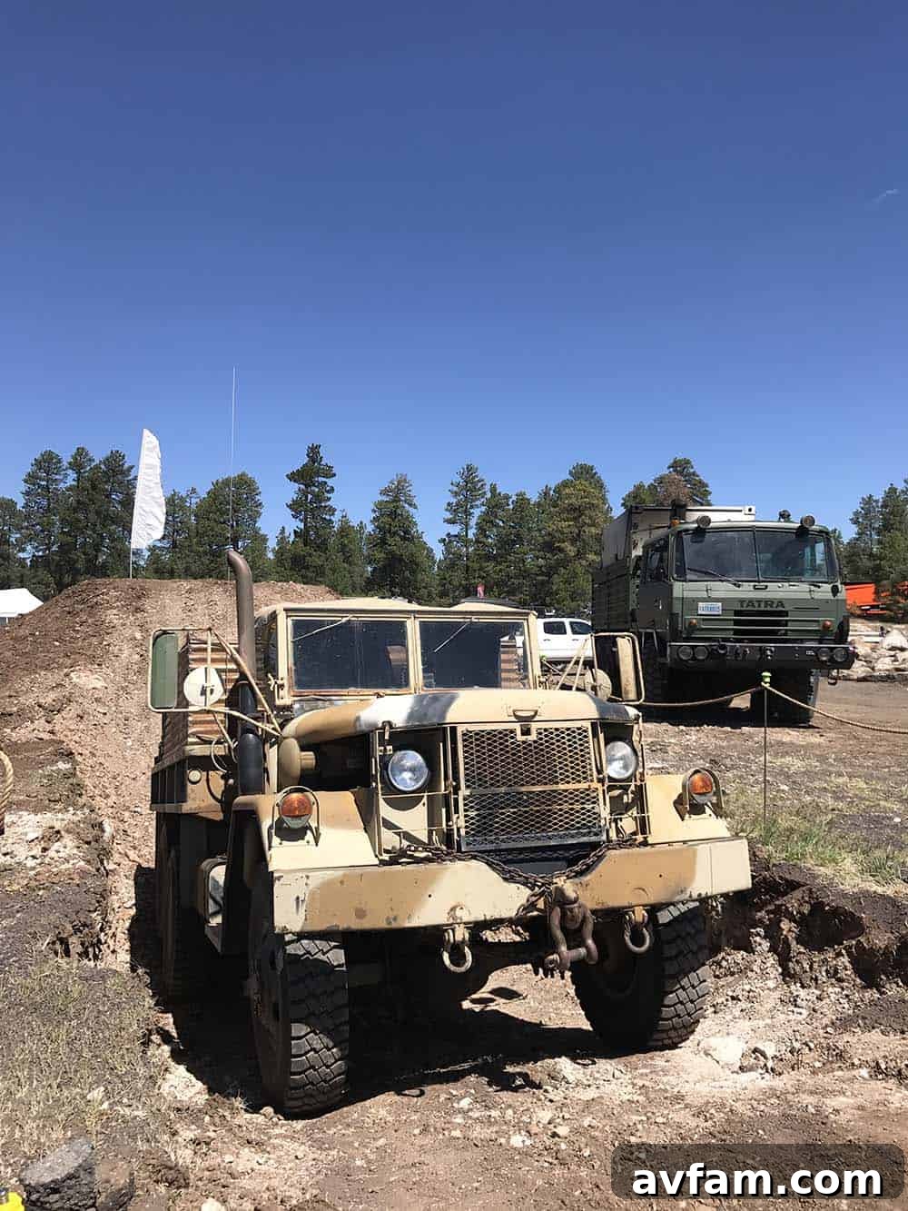 A detailed view of an overland vehicle's front grille and bumper, equipped with a winch and recovery points.