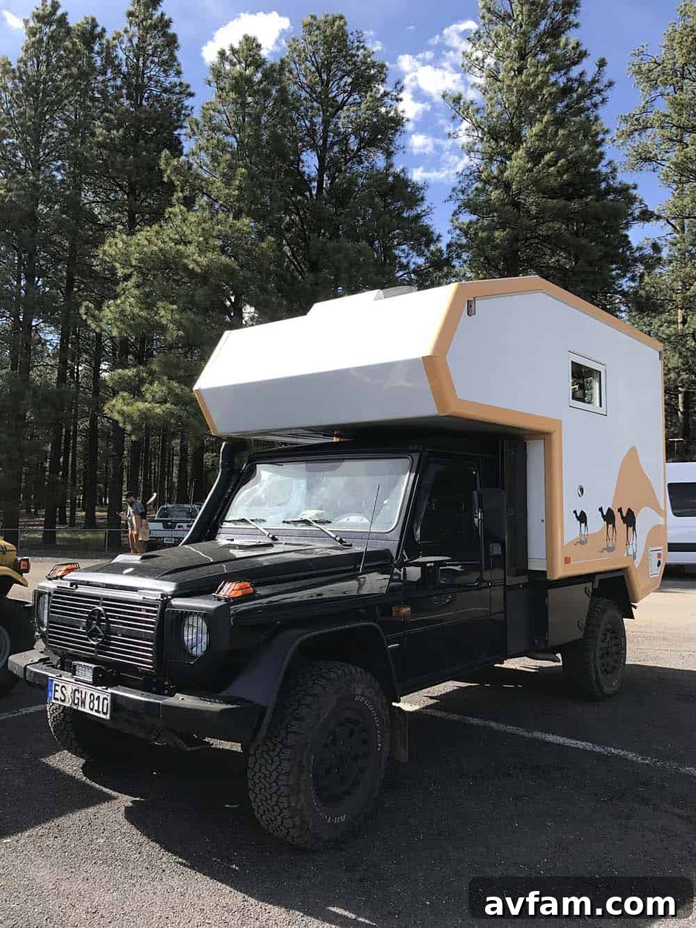 A black Toyota FJ Cruiser, heavily modified for off-road expeditions, with a roof rack and ample storage.