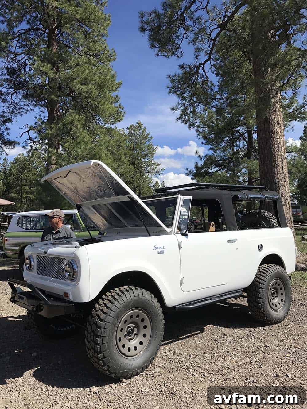 A modern off-road truck with a custom bed camper, featuring an awning deployed for shade and relaxation.