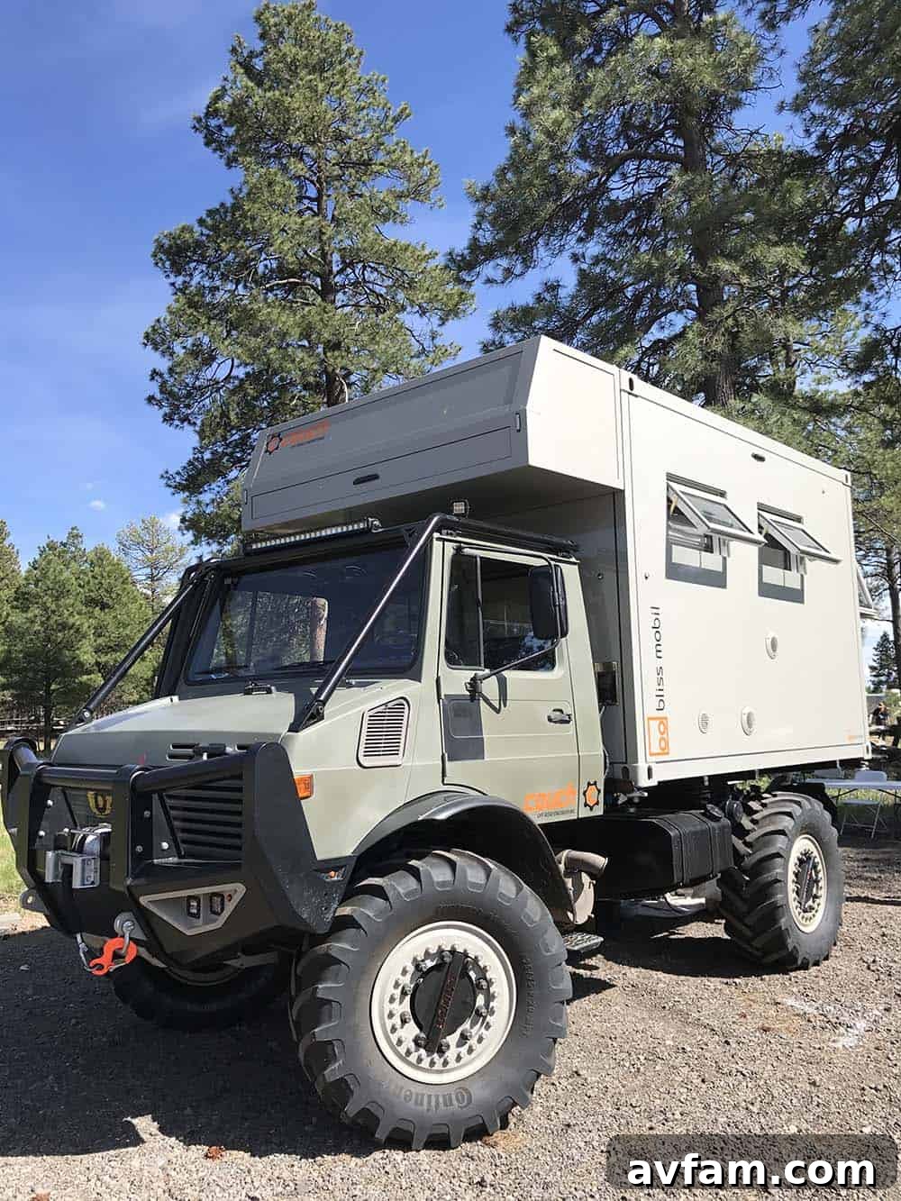 A gray Ford Bronco with a unique custom pop-top camper, combining classic style with modern overlanding features.