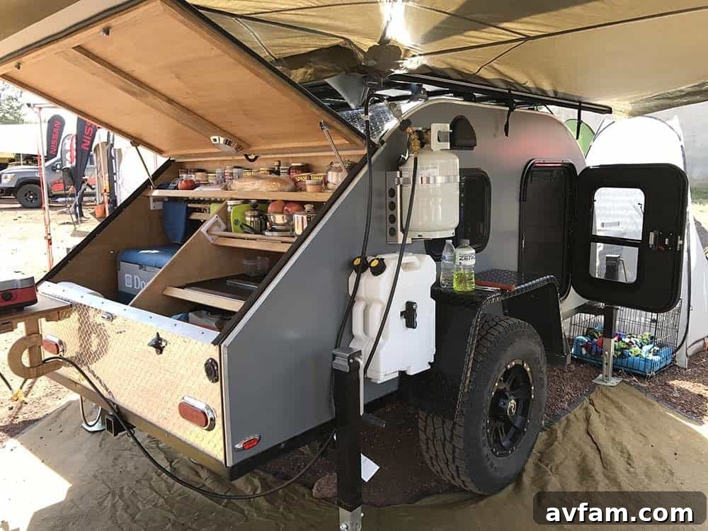 An older model Dodge Ram pickup truck, transformed into an overland expedition vehicle with a large custom camper.