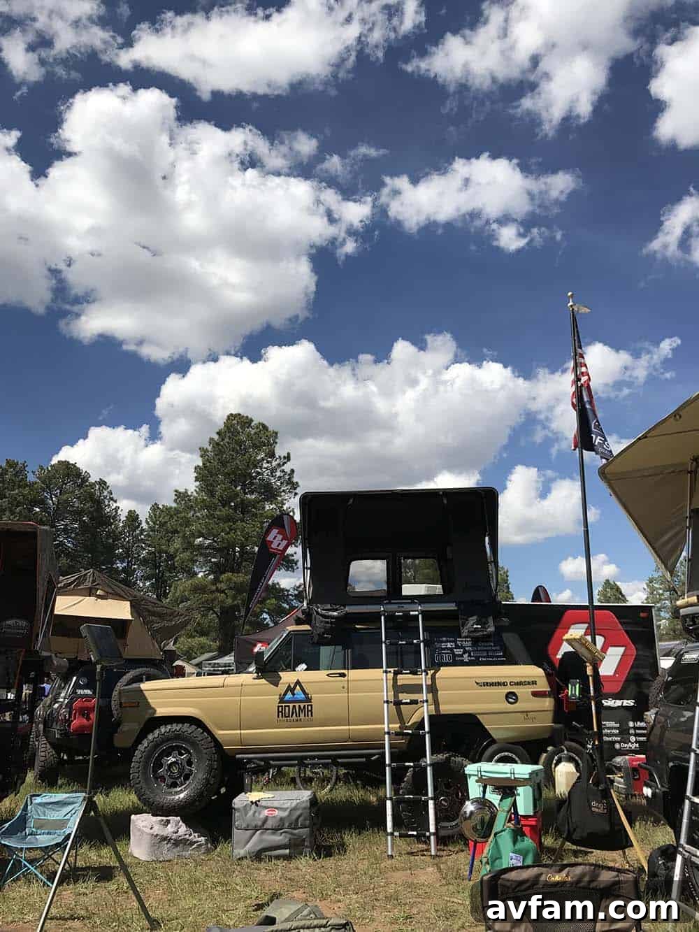 A green Ford F-Series pickup truck, featuring a full-size bed camper and heavy-duty modifications for long expeditions.