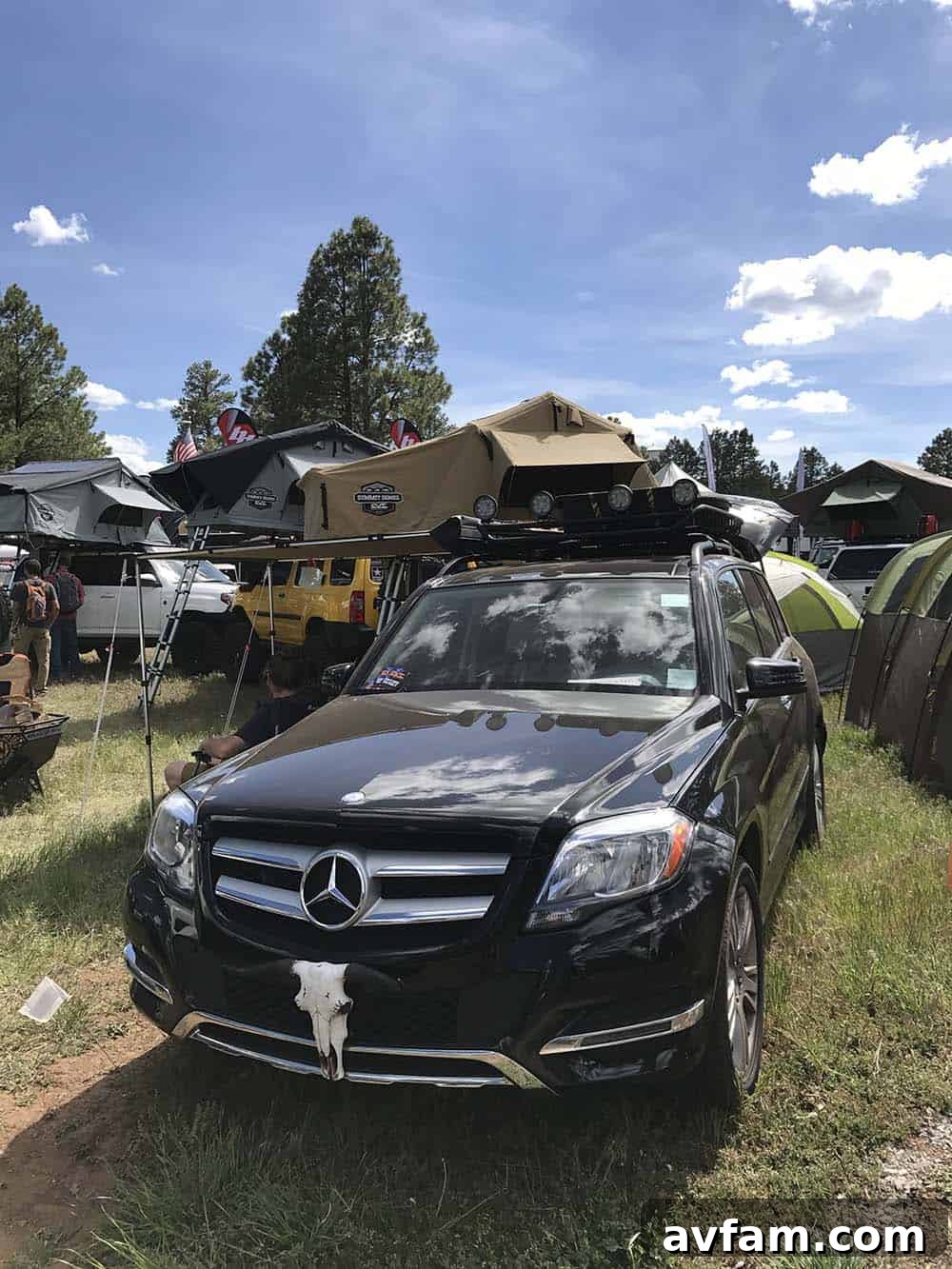 An older model Toyota Land Cruiser, possibly an 80 Series, with a lifted suspension and roof rack, a classic overland choice.