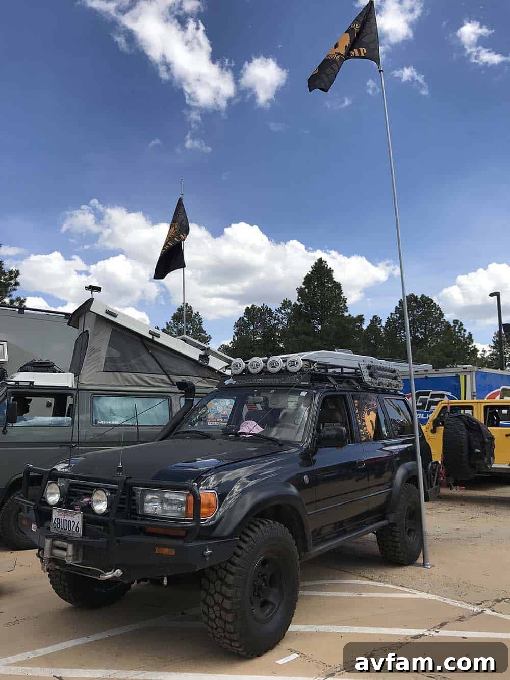 A black Toyota Tacoma pickup truck with a compact pop-top camper, offering a low-profile yet functional living space.