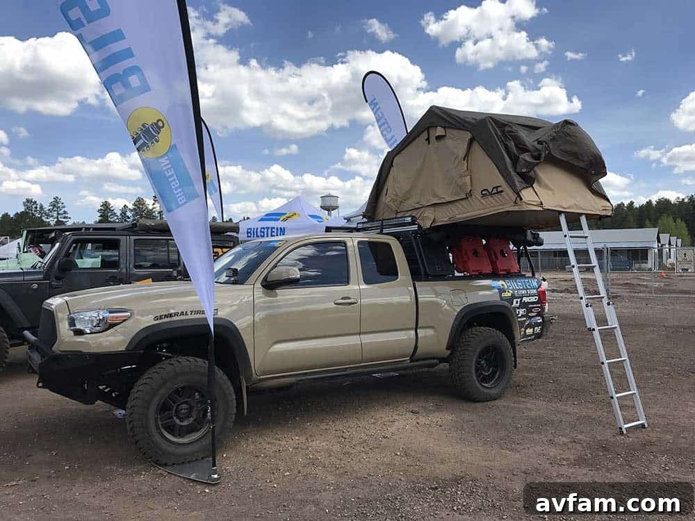 An orange EarthRoamer expedition vehicle, a top-tier luxury overland rig, captivating attendees at the expo.