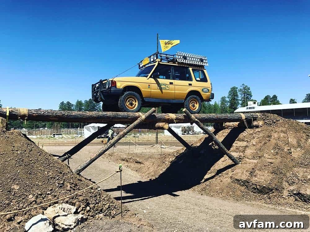 A modern grey overland truck with a high-clearance suspension and a well-equipped bed camper, ready for remote camping.