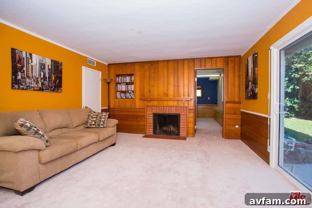 Before painting: Den with dark wood paneling and brown paint, showing its original, unrenovated state