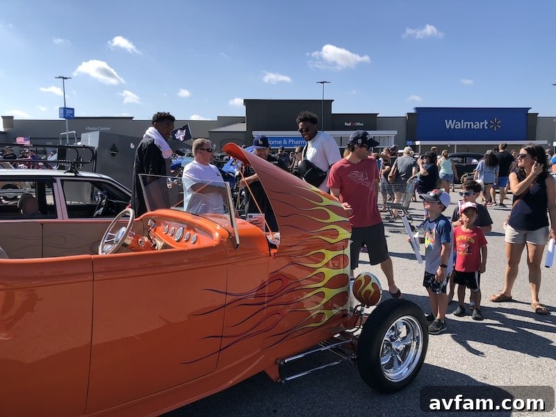 A high-angle shot of a custom hot rod at a Hot Wheels Legends Tour event, showcasing its unique design and vibrant paint job under outdoor lighting.
