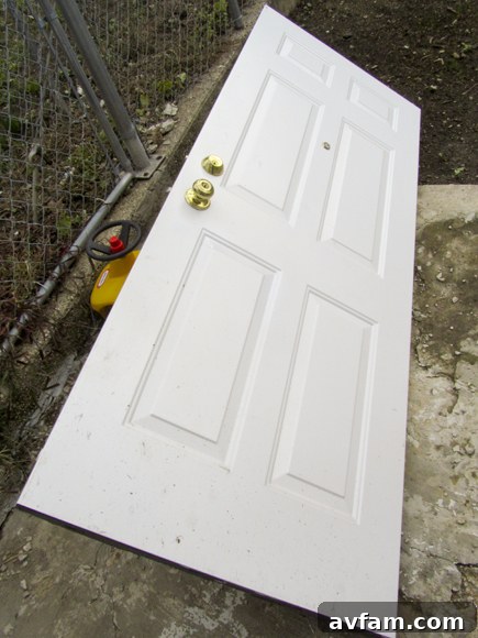 Door Removed for Installation An exterior door has been removed from its hinges and laid flat on a workbench, ready for new weatherstripping installation.