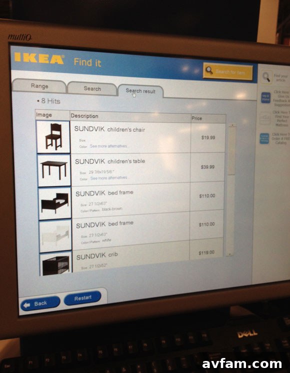 Close-up of a person using an IKEA self-service computer kiosk to search for products.