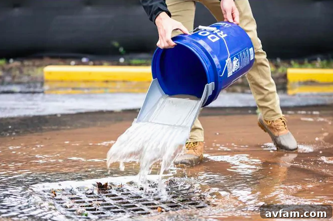 The Quiklid bucket scoop efficiently removing a significant amount of standing water from a floor, showcasing its superior design for liquid cleanup.