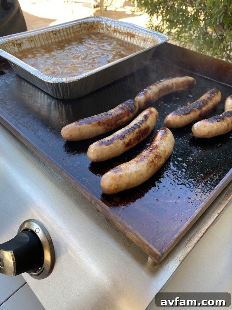 Cooking multiple items: carne asada and brats in a foil pan on the griddle.