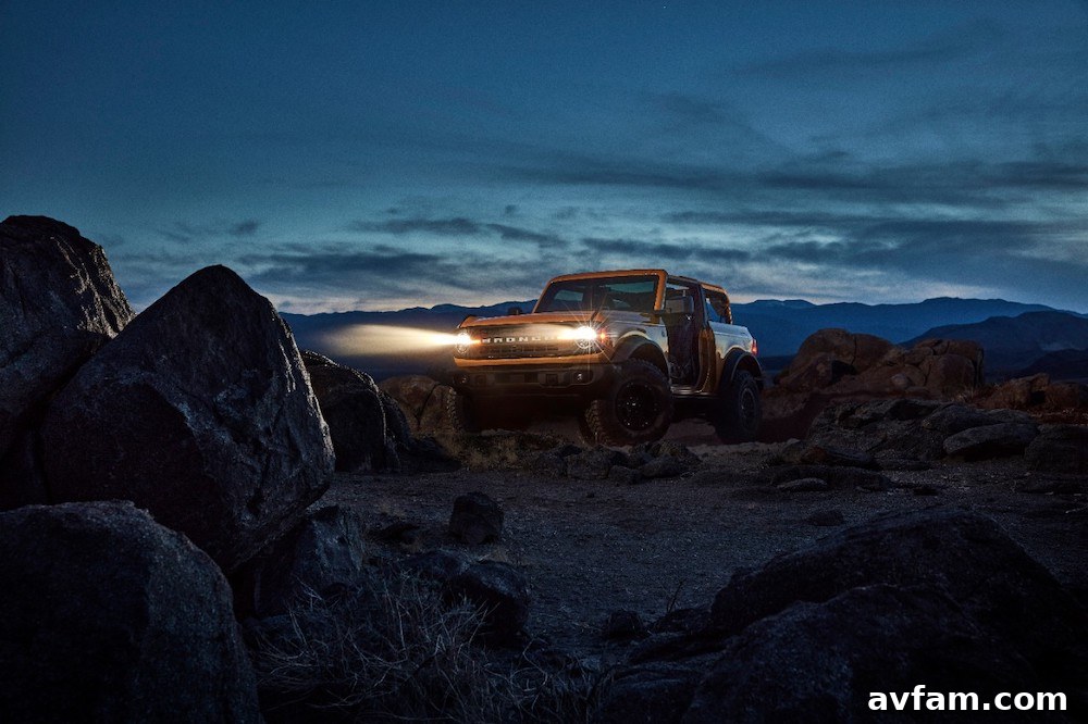 The Ford Bronco navigating a challenging dirt track in a forest.
