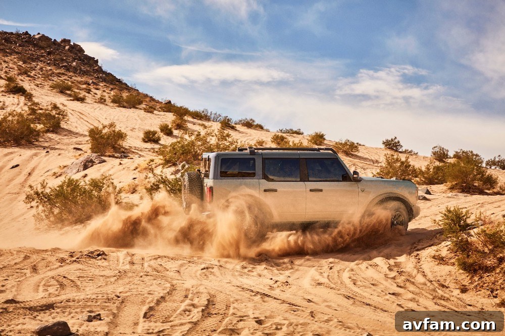 A high-angle view of the Ford Bronco driving on a sandy trail.