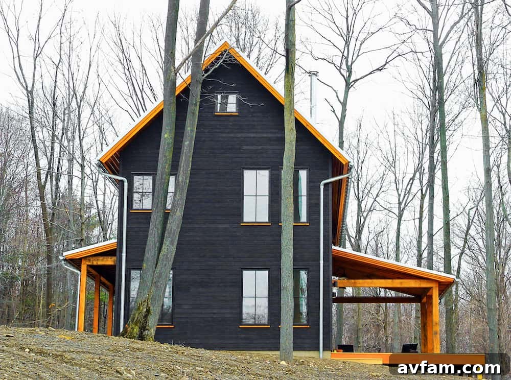 Home with a harmonious mix of charred wood siding, concrete, and expansive glazing.