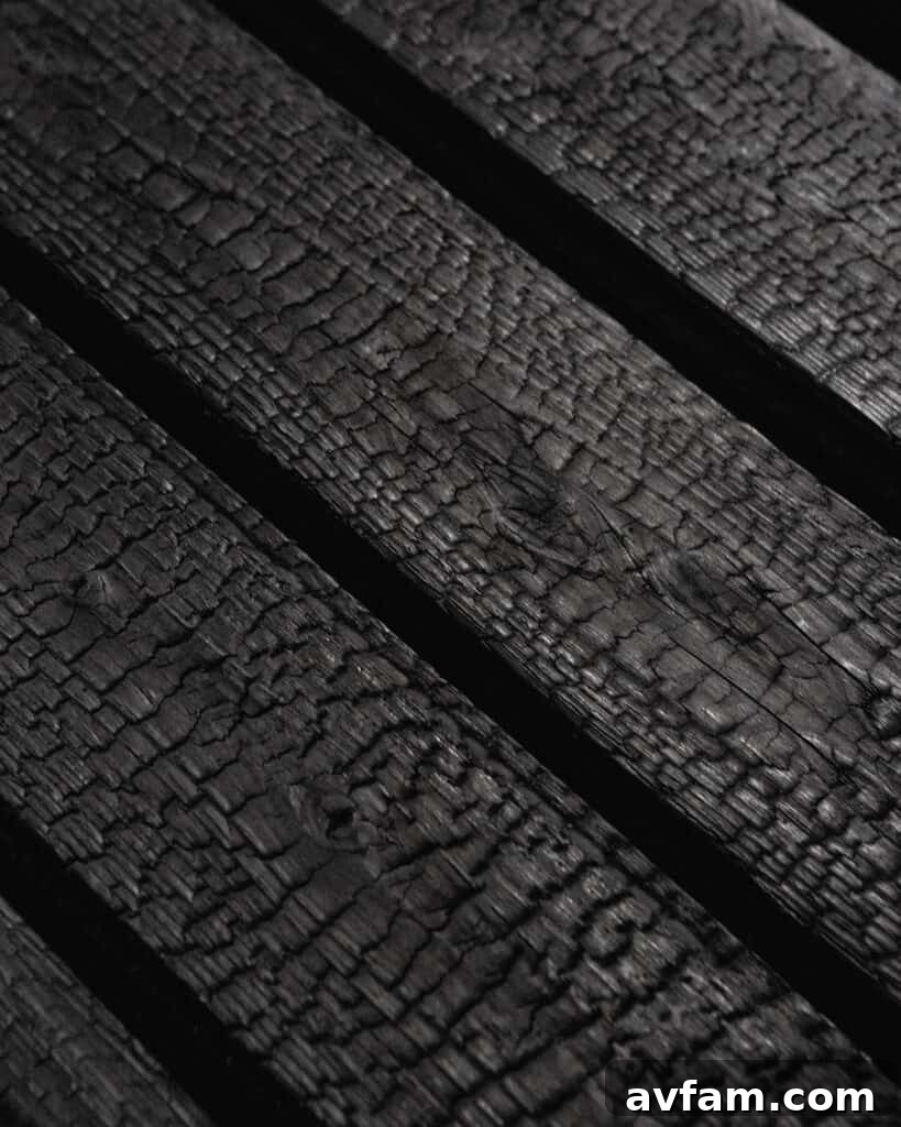 Architectural close-up of deeply textured charred wood siding on a contemporary facade.