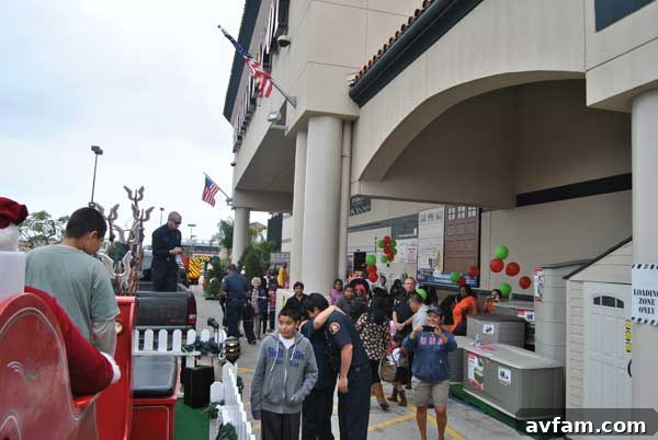 A long line of children and parents gather, anticipating their turn to meet Santa Claus at Home Depot's fire safety event.