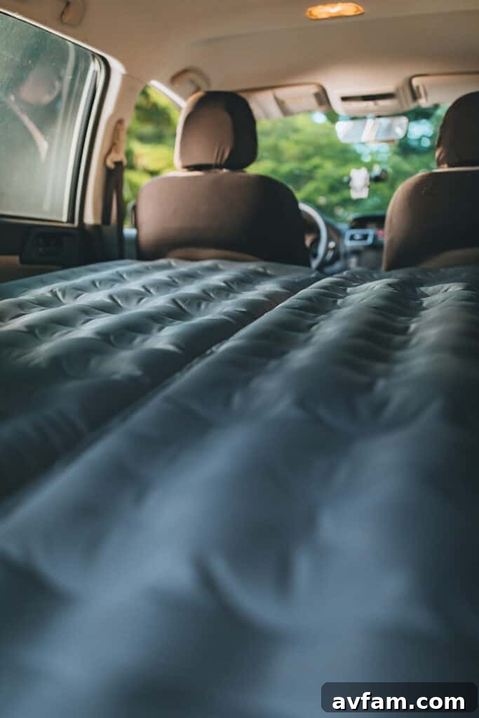 A person enjoying a relaxed moment inside a vehicle equipped with a Luno Air Mattress, depicting the comfort and ease of car camping