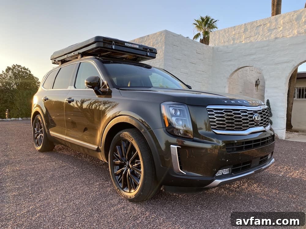 Kia Telluride with Roofnest Sparrow rooftop tent driving on a desert road