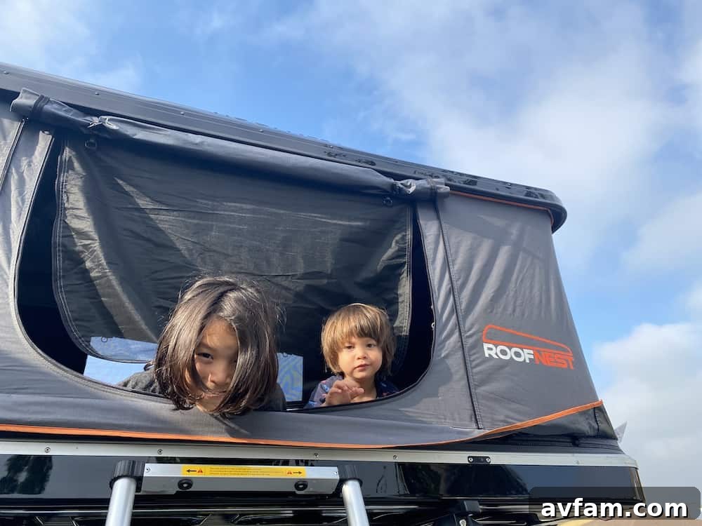 Open Roofnest Sparrow rooftop tent on an SUV at a picturesque location
