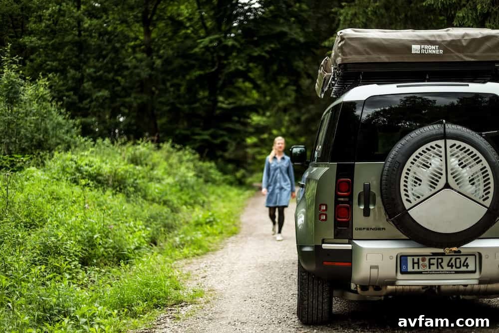 Land Rover Defender 110 off-road with roof rack in scenic landscape