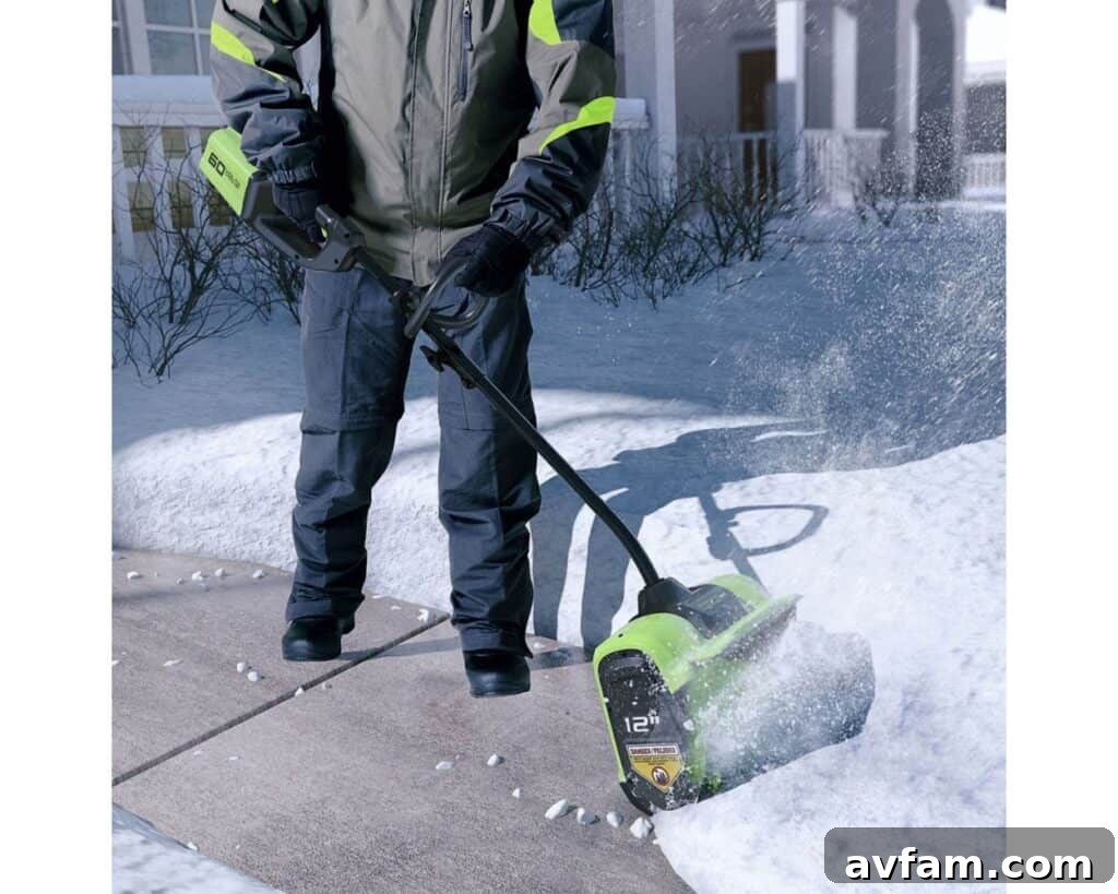 greenworks snow shovel in action on a sidewalk