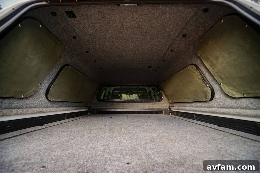Individual measuring a truck cap window with cardboard for a DIY template.