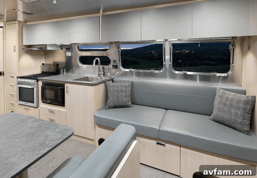A person working intently at the ergonomic desk of the Airstream Flying Cloud 30FB Office, emphasizing focus and productivity on the road.