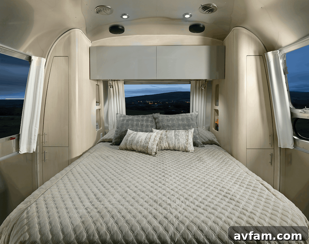 Interior view of the Airstream Flying Cloud 30FB Office showcasing the dining area and kitchen, highlighting the comprehensive living amenities.