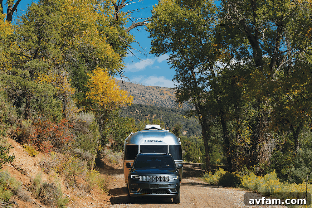 Exterior shot of the Airstream Flying Cloud 30FB Office, highlighting its iconic silver bullet design against a natural backdrop.
