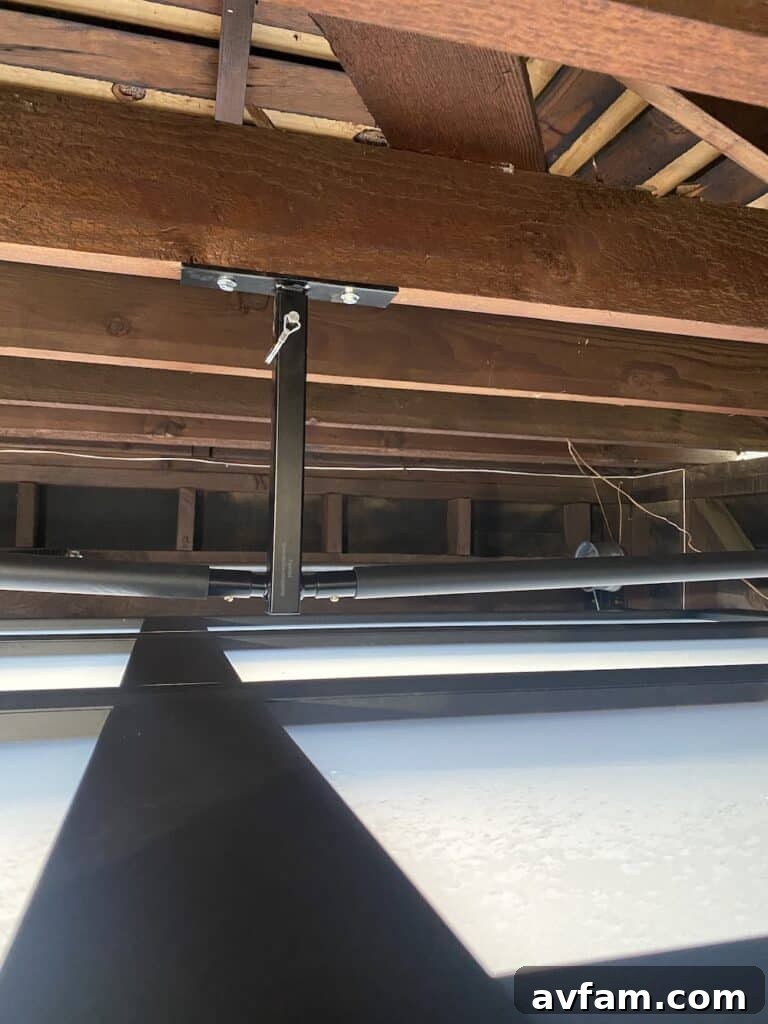 Detailed view of the surfboard rack adjusted to clear a rising garage door