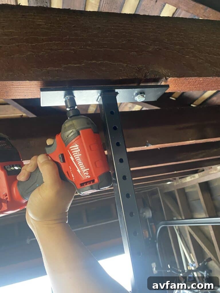 Close-up of a marked garage beam, indicating the precise location for drilling lag bolts