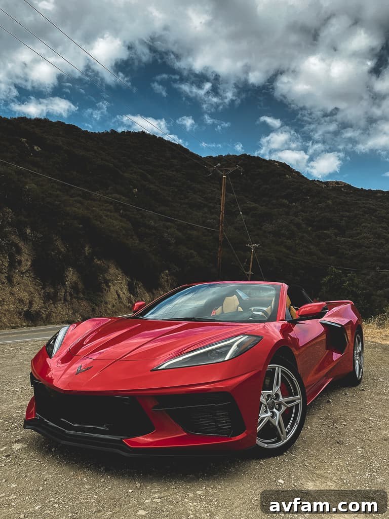 Sleek red 2020 Corvette C8 Convertible showcasing its aggressive front design with headlights on.