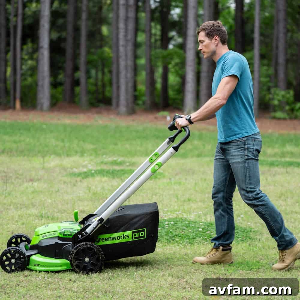 Greenworks Cordless Hedge Trimmer in Use A person expertly trimming a neatly manicured hedge with a Greenworks 60V cordless hedge trimmer, showcasing precision and ease.