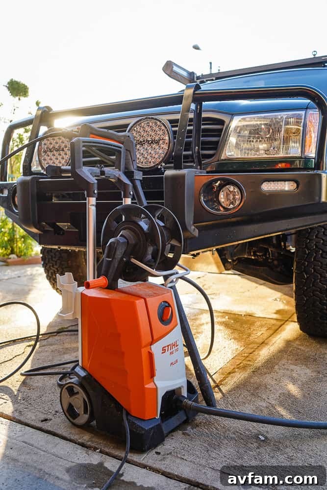 A homeowner using the STIHL RE 110 Plus pressure washer to clean a patio surface, showcasing its ergonomic design and powerful spray.