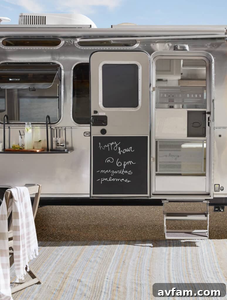 The luxurious onboard bathroom of the Airstream Pottery Barn trailer, featuring a round vessel sink, matte-black faucet, and elegant wall sconces.