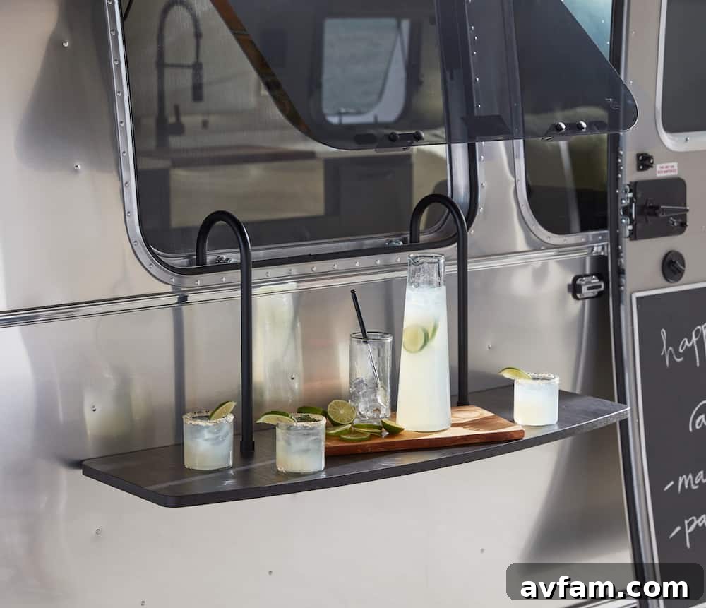 A wide interior shot of the Airstream Pottery Barn living area, showcasing its spacious layout and abundant natural light from the panoramic windows.