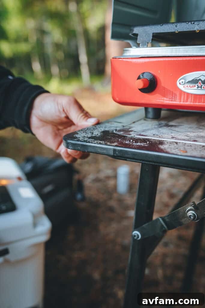 Camping gear laid out at the campsite, including Yeti chairs, duffels, and a cooler, highlighting essential overlanding equipment