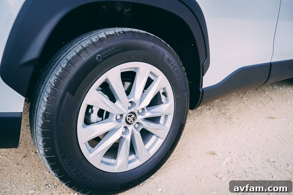 The 2022 Toyota Corolla Cross parked on a gravel path next to lush greenery.