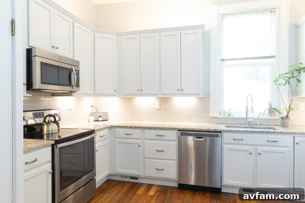 Richmond Restoration: A Historic House Reborn 26 After kitchen renovation: Modern white cabinets, gray subway tiles, granite countertops, and stainless steel appliances